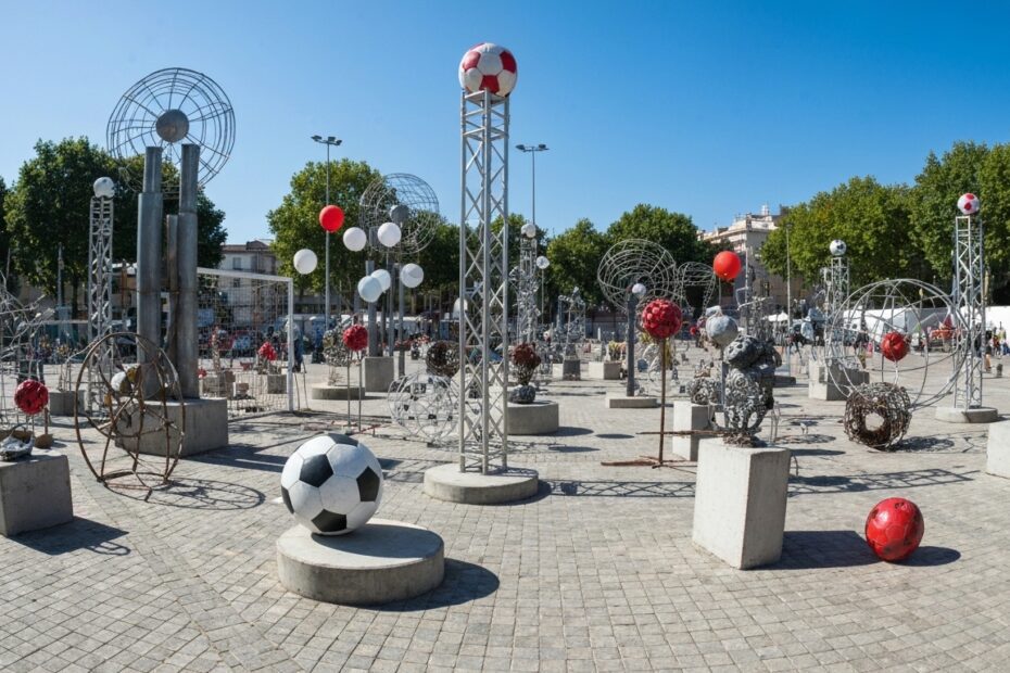 Instalação de arte contemporânea inspirada em futebol com elementos esculturais e interação pública