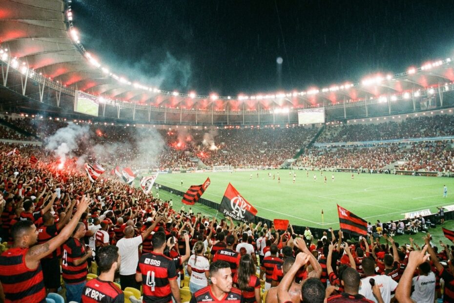 Estádio do Maracanã iluminado à noite com torcida do Flamengo presente nas arquibancadas